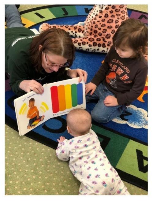 Cindy reads to children at story time.